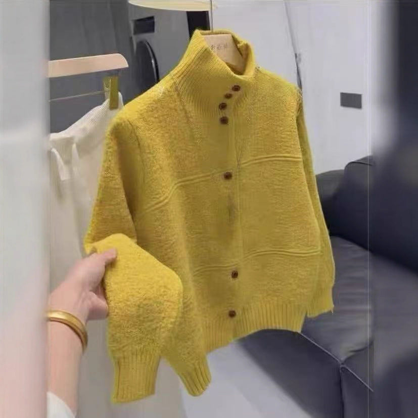 Manteau-cardigan long en tricot jaune, sur cintre, détail de la manche, vue de face