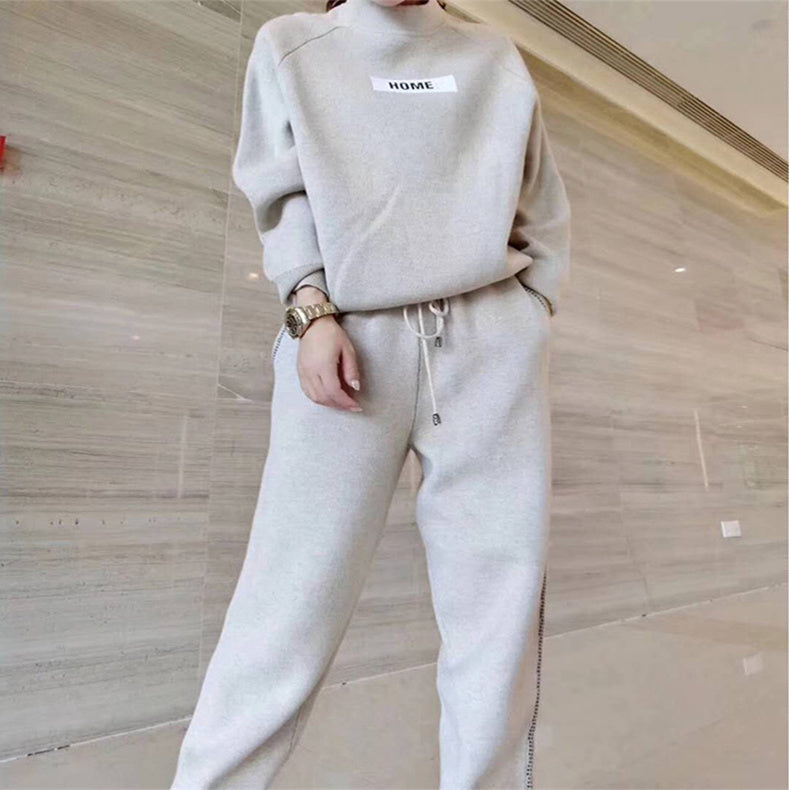 Femme portant l'ensemble en tricot et cachemire beige crème, sweat-shirt à écusson HOME et pantalon assorti, vue du buste aux genoux