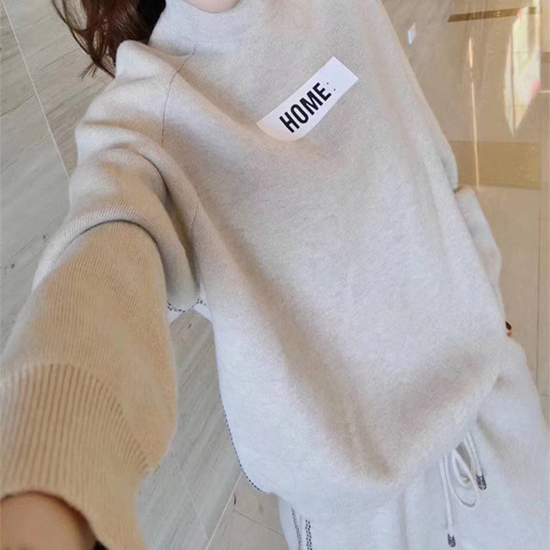 Gros plan sur le sweat-shirt beige crème de l'ensemble en tricot et cachemire, écusson HOME sur la poitrine