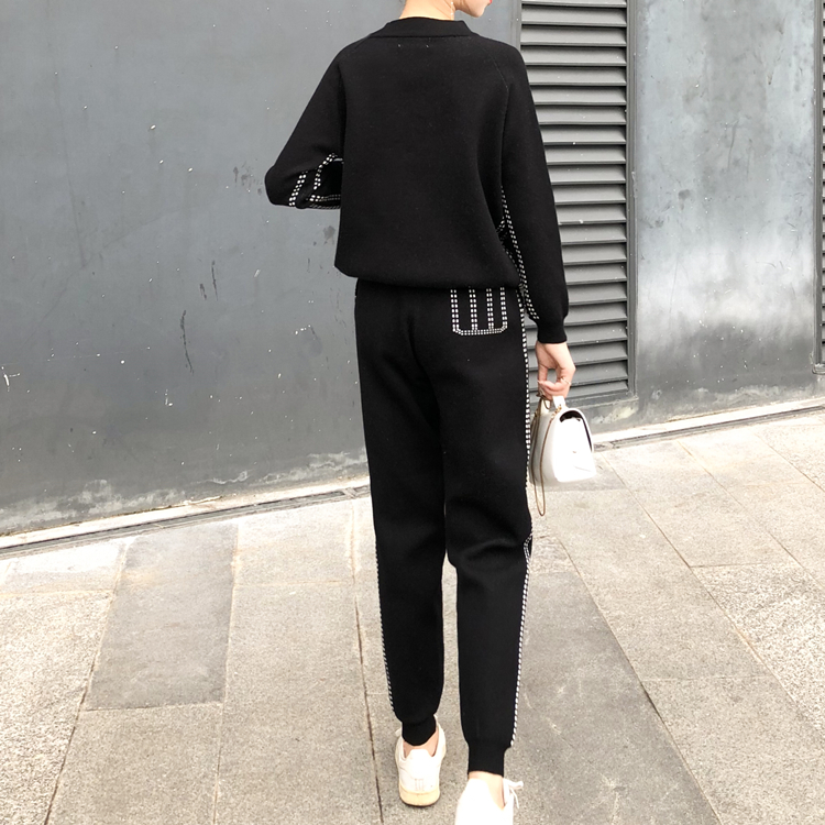 Femme portant l'ensemble en tricot et cachemire noir, sweat-shirt et pantalon assortis, vue de dos en extérieur