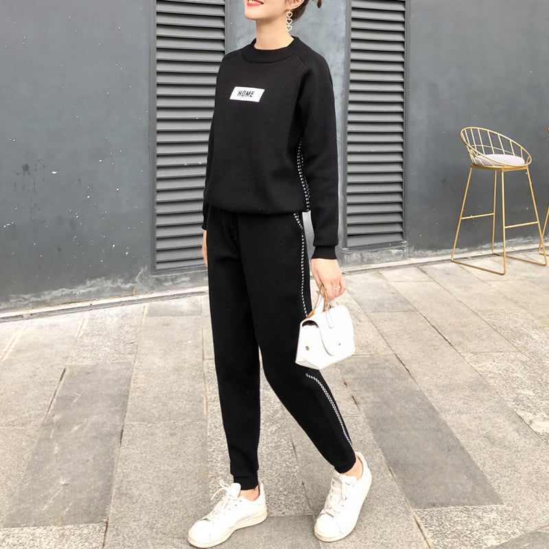 Femme portant l'ensemble en tricot et cachemire noir, sweat-shirt et pantalon assortis, debout en extérieur