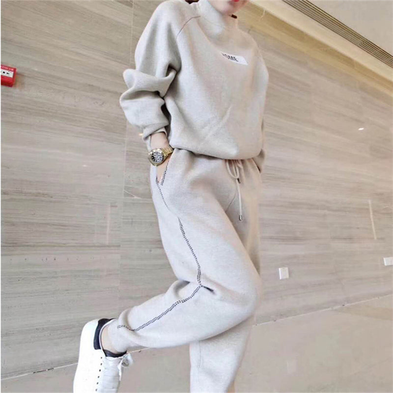 Femme portant l'ensemble en tricot et cachemire beige crème, mains dans les poches du pantalon, vue en entier
