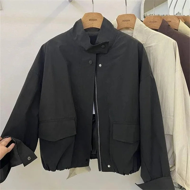 Veste coupe-vent col montant noire, sur cintre, vue de face