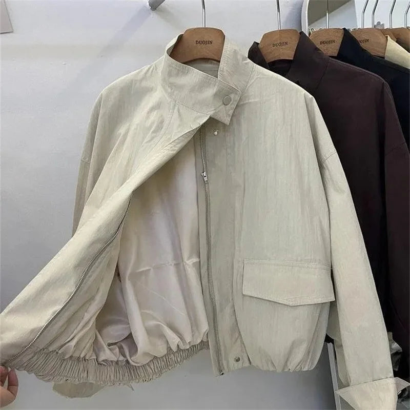 Veste coupe-vent col montant beige, ouverte, sur cintre, vue de face