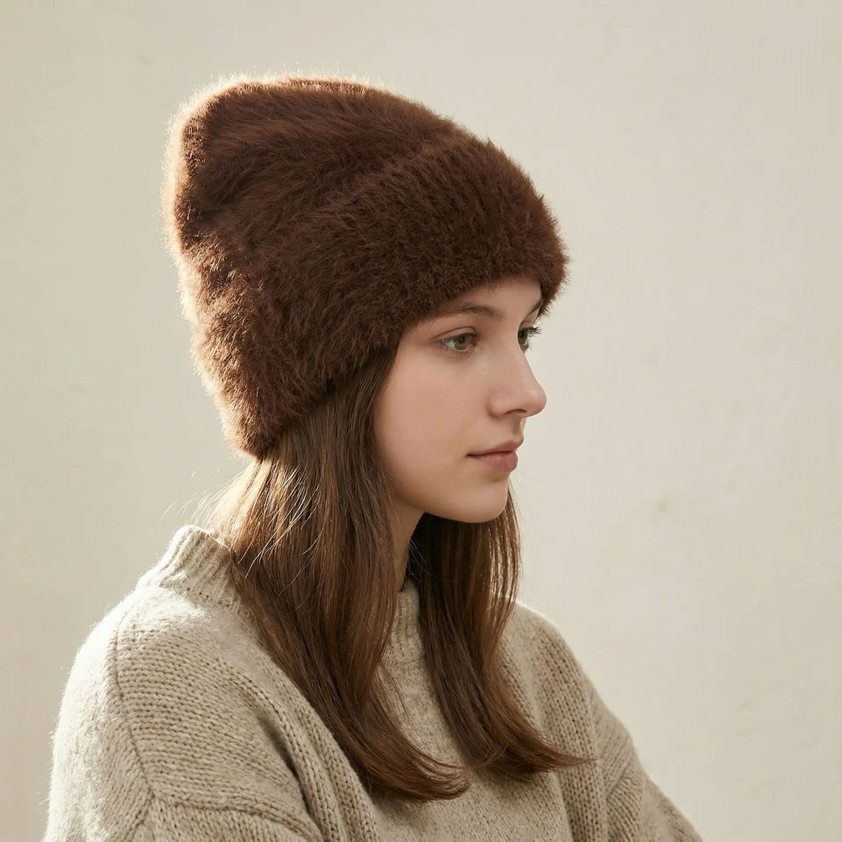 Modèle portant un bonnet brun en alpaga et un chandail en tricot