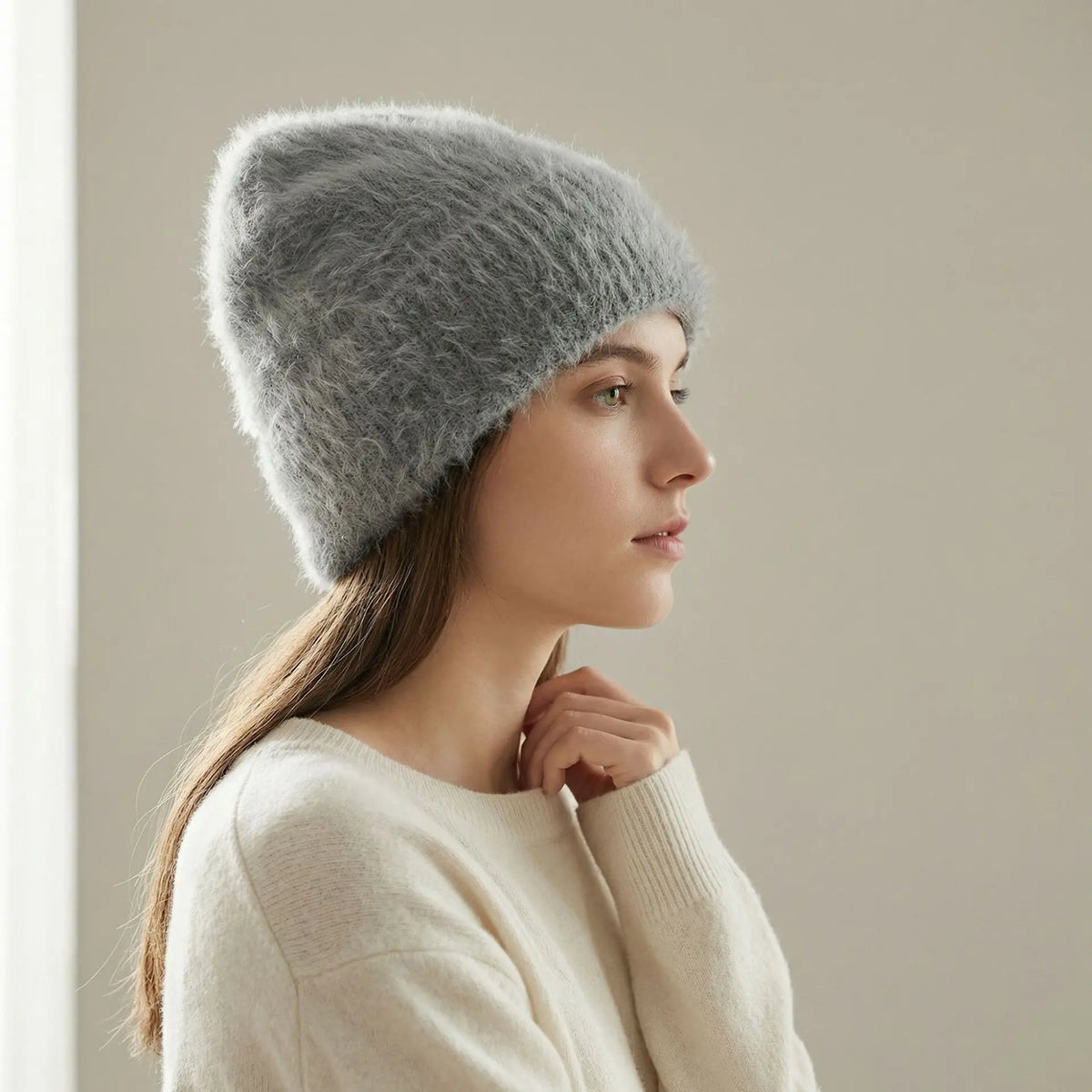 Modèle portant un bonnet gris en alpaga et un chandail crème