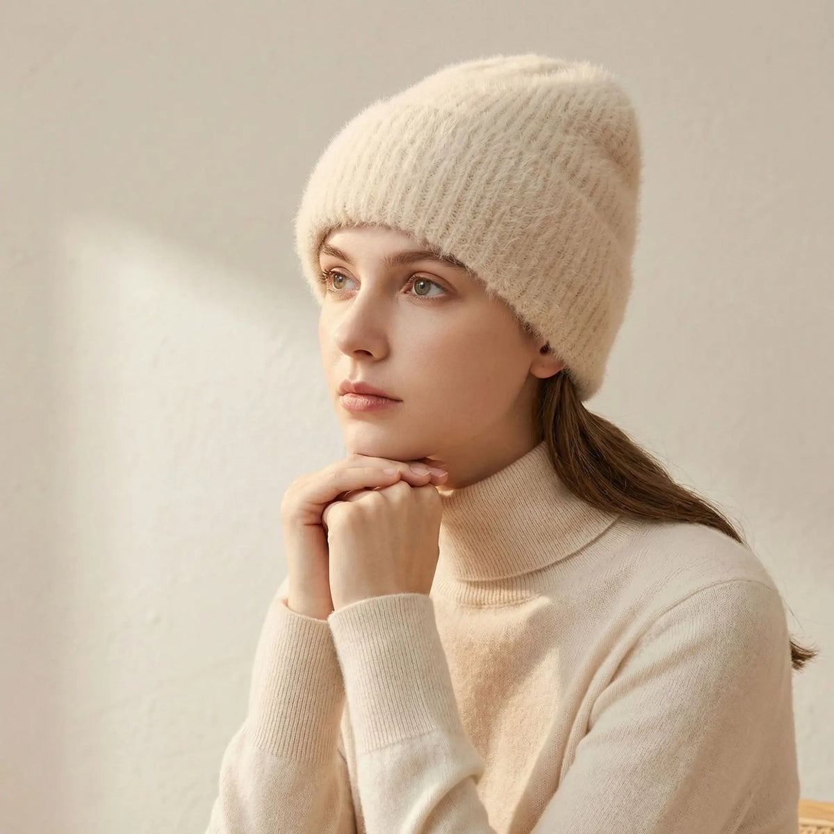 Modèle portant un bonnet crème en alpaga, assorti à un col roulé