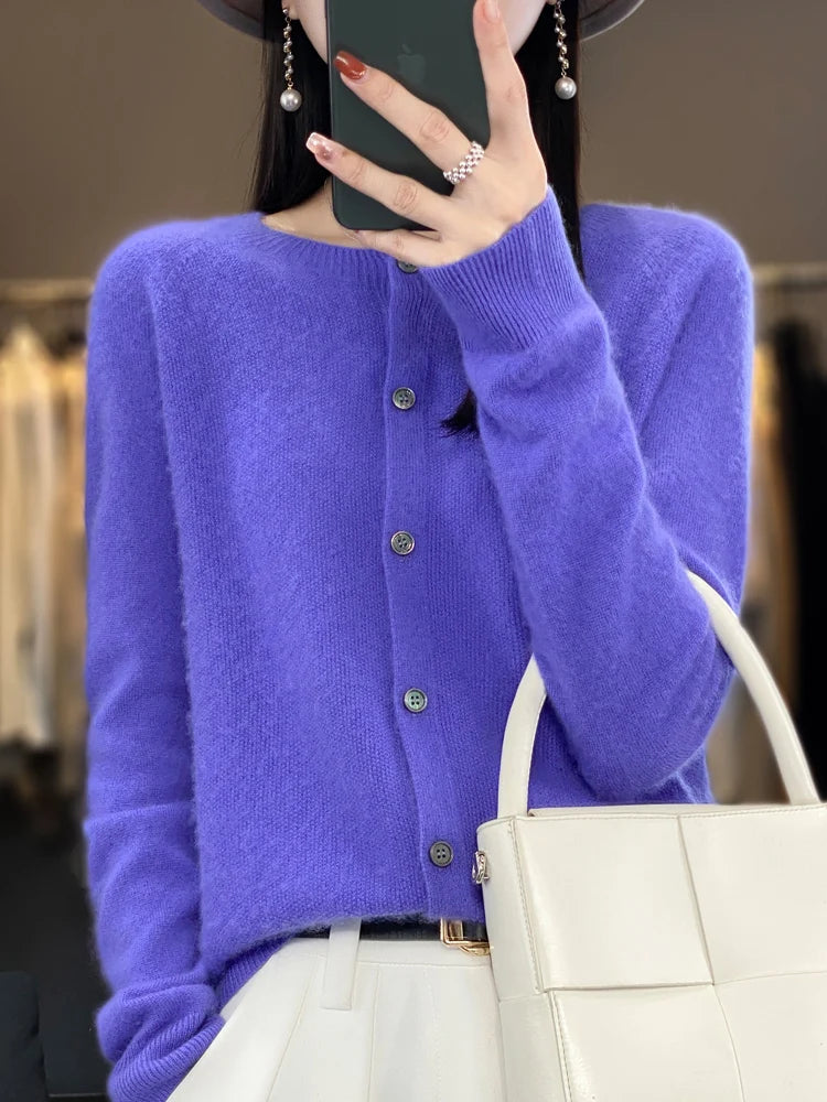 Modèle portant un cardigan violet en laine mérinos à boutons tenant un sac à main blanc, vue de face