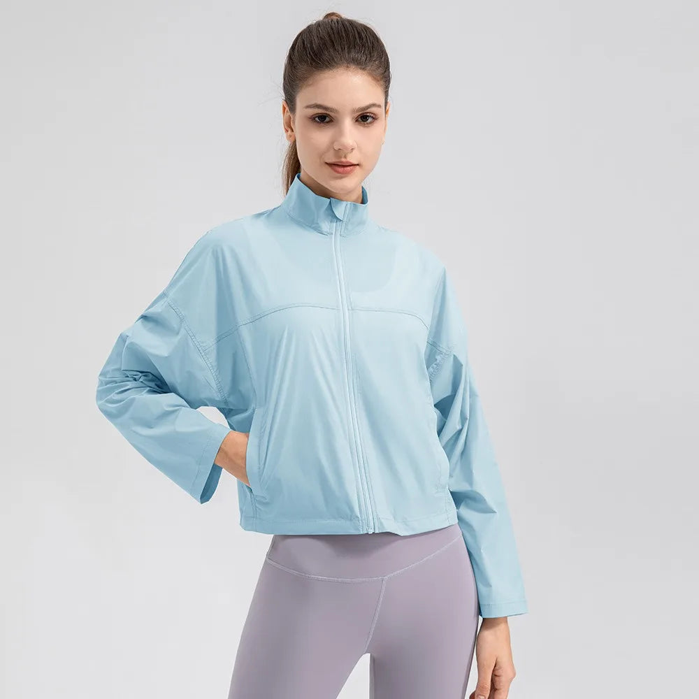Veste légère anti-UV bleue zippée, portée, main dans la poche, vue de face sur fond blanc