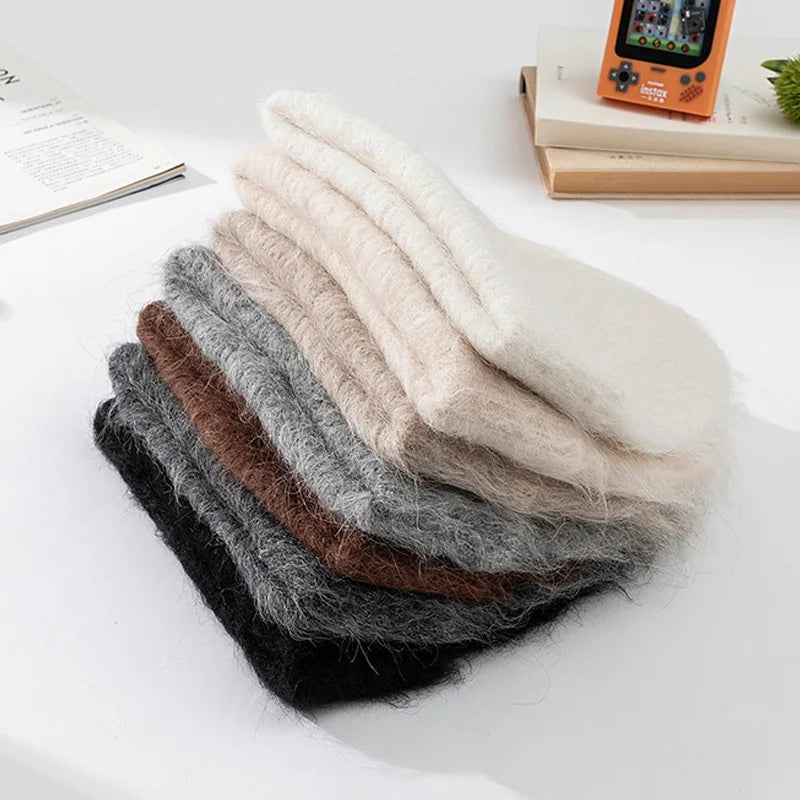 Pile de bonnets en alpaga pliés, plusieurs coloris