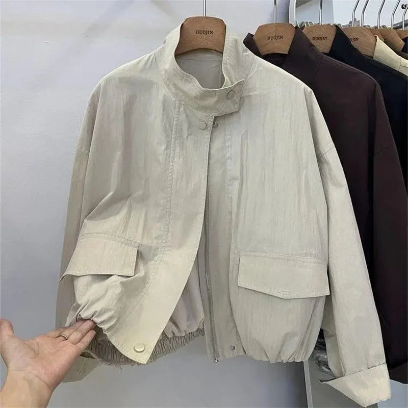 Veste coupe-vent col montant beige, fermée, sur cintre, vue de face