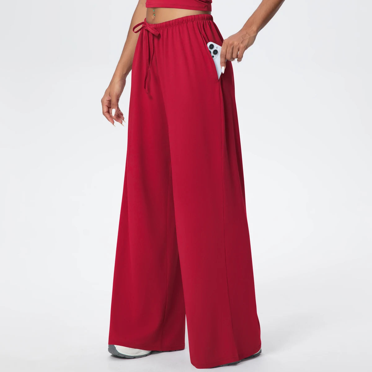 Pantalon de yoga taille haute rouge, jambe large à poches, porté, vue de face