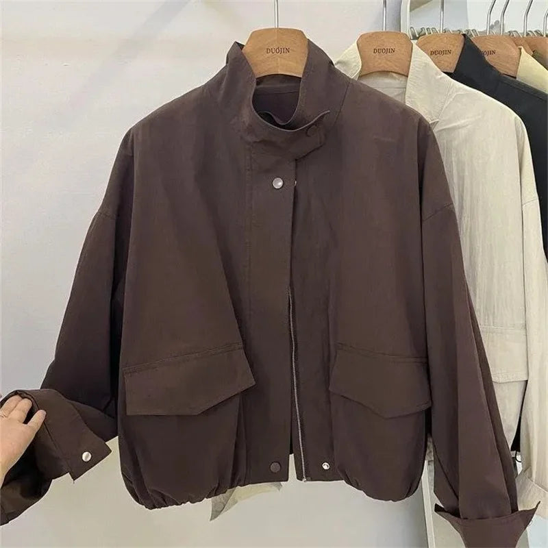 Veste coupe-vent col montant marron, détail du devant, sur cintre