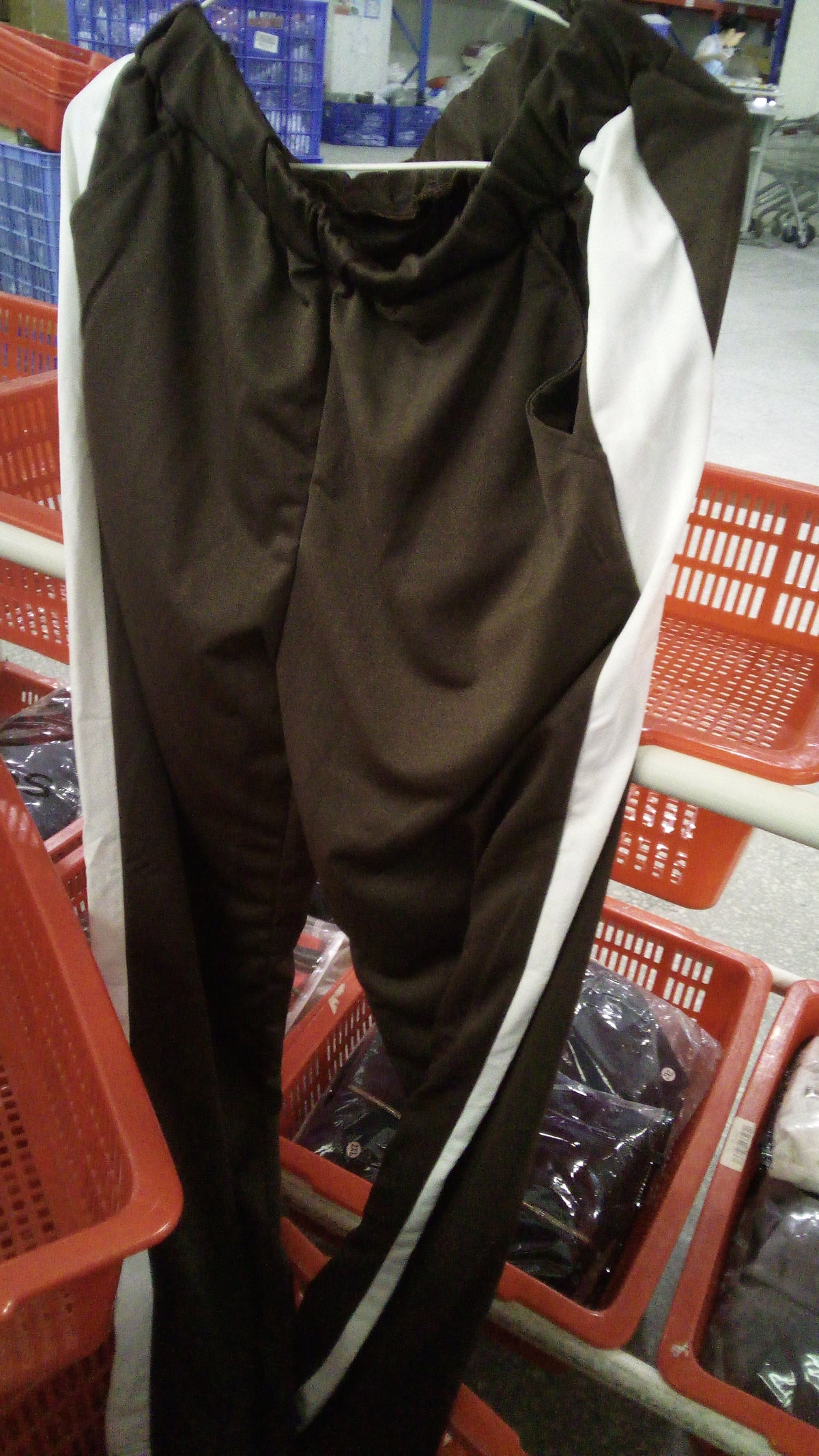 Pantalon de l'ensemble survêtement color-block brun foncé à bandes blanches, sur cintre
