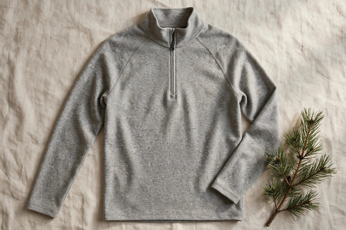 Haut thermique demi-zip en laine mérinos gris – présenté à plat sur lin écru